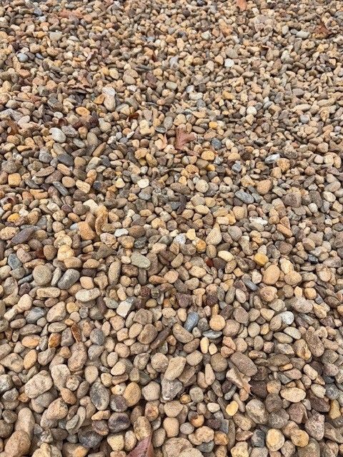 Brown and tan gravel stones, small and rounded, fill the frame.