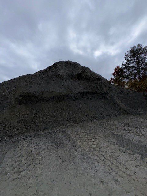 Pile of gray gravel under a cloudy sky.