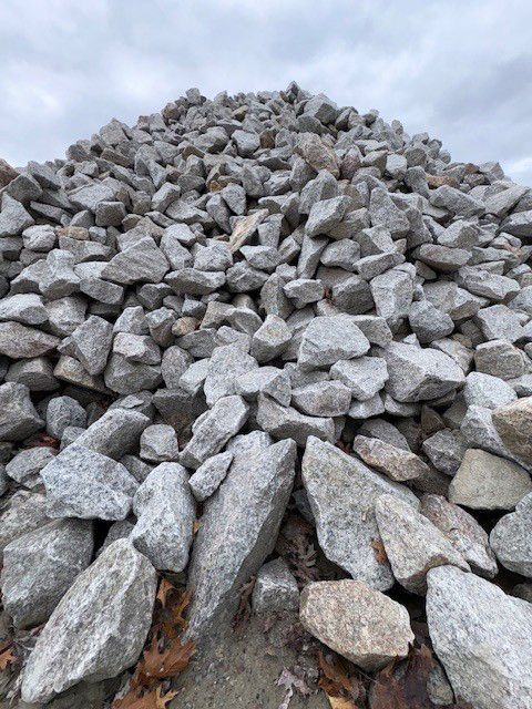 Pile of gray and tan rocks against a cloudy sky.
