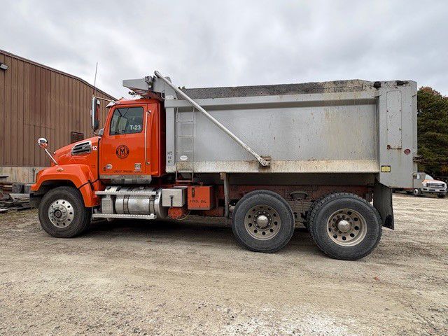 Orange dump truck parked outside a building.