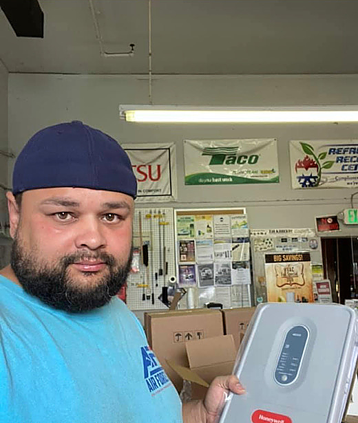 a man with a beard wearing a blue hat is holding a box