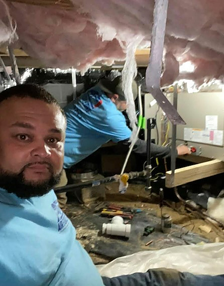 a man in a blue shirt is working under a ceiling