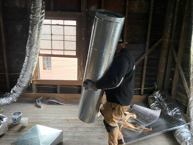 a man is carrying a large metal pipe in a room