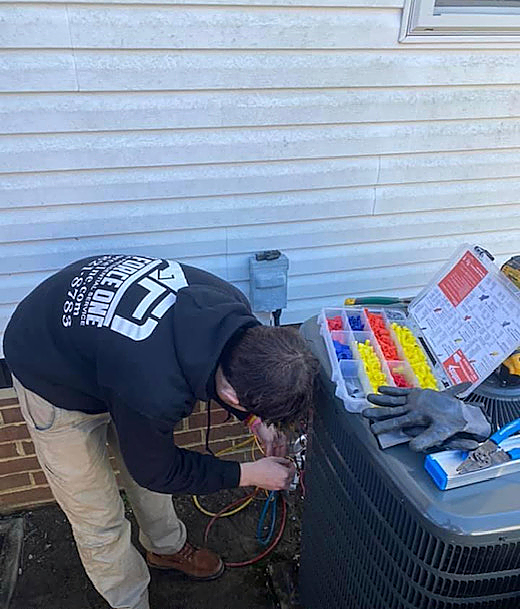 a man is working on an air conditioner outside of a house .