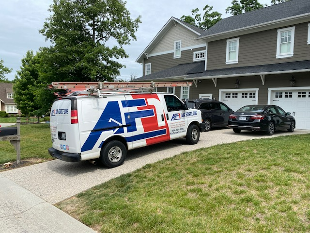 a red , white and blue van is parked in front of a house .