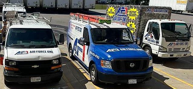 three vans are parked next to each other in a parking lot .
