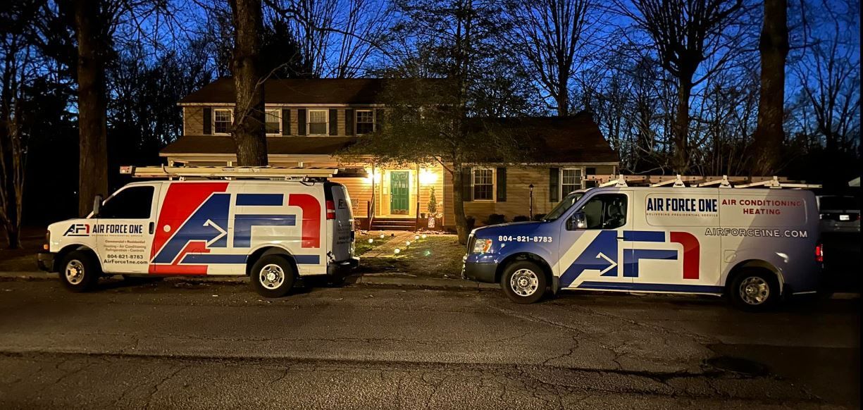 two vans are parked in front of a house at night .