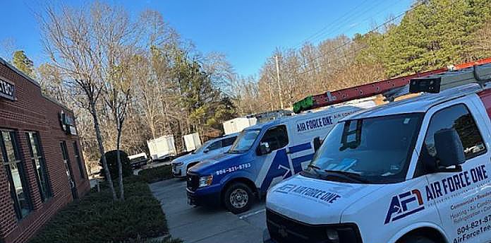 a row of vans parked in front of a building .