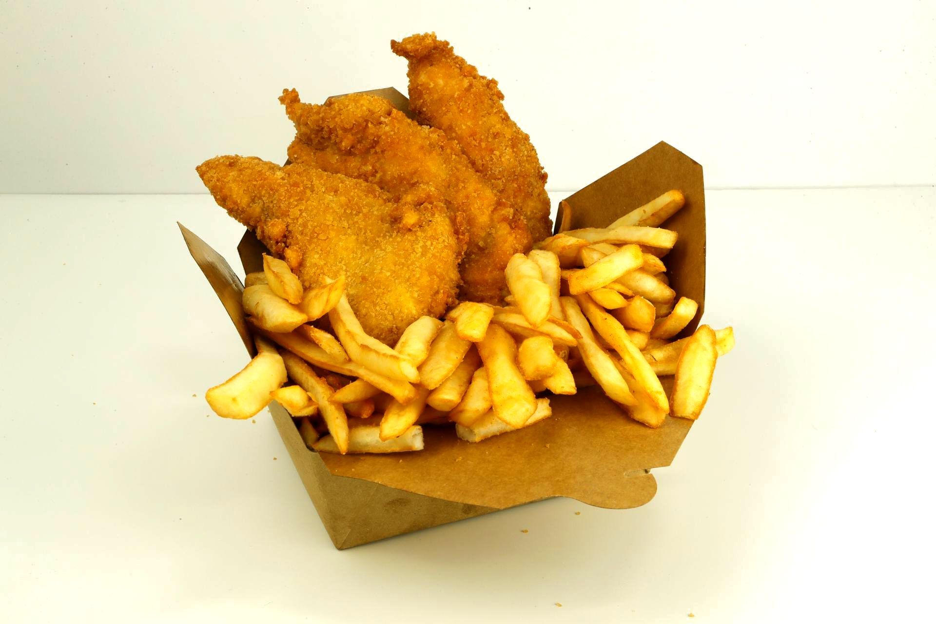 Fried chicken tenders, french fries, and dipping sauce on a printed paper, likely from a restaurant.