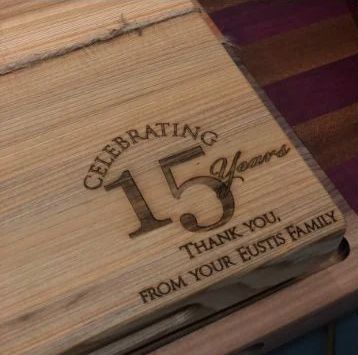 Wooden plaque engraved 'Celebrating 15 years,' thanking the Eustis family.