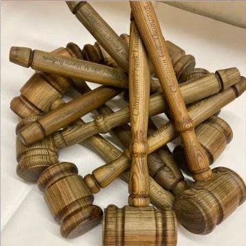 Pile of wooden mallets with carved handles, overlapping on a light background.