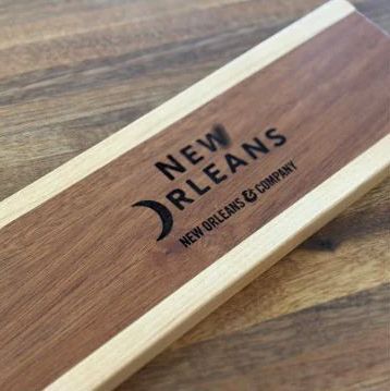 Wooden box lid with New Orleans company logo on a wood-grain tabletop