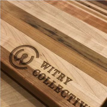 Wooden surface engraved with the 'WITRY COLLECTIVE' logo in dark lettering.