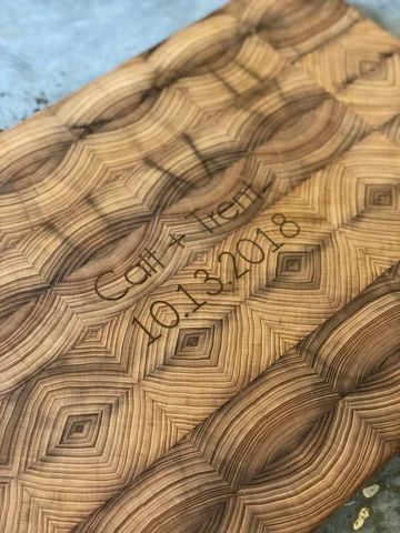 Wood-grain engraved wooden board with a name and phone number etched in the center.