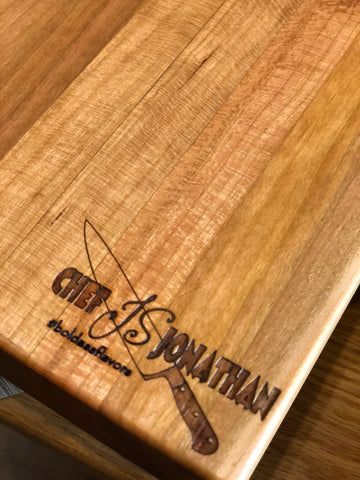 Engraved wooden paddle with cursive name on a light wood tabletop