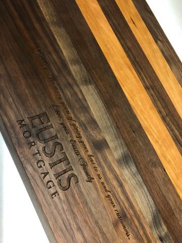 Wooden cutting board with dark and light stripes and the engraved logo 'Fustis Forged.'