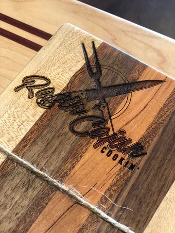 Wooden plaque with dark bird logo and cursive text, on a rustic wood surface.