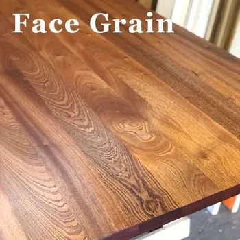 A close-up view of dark, rich wood showing prominent wavy grain patterns with the text 