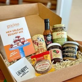 Gift basket of gourmet foods and drinks in an open cardboard box
