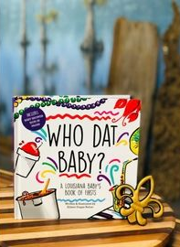 A colorful board game box labeled 'Who Dat Baby?' sits on a wooden table alongside baby items and a toy insect.