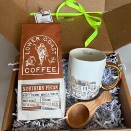 Coffee gift box with Low Coast Coffee bag, white mug, and wooden scoop on shredded paper packing