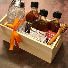 Gift basket with bottles of beer and a glass mug, tied with an orange ribbon.