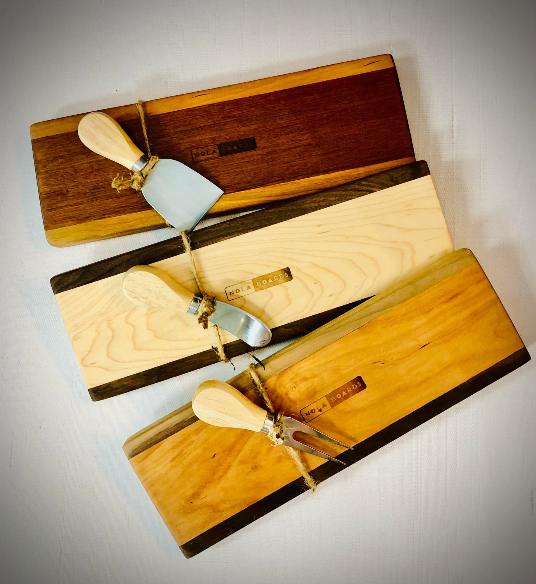 A wooden cutting board with the word nola on it