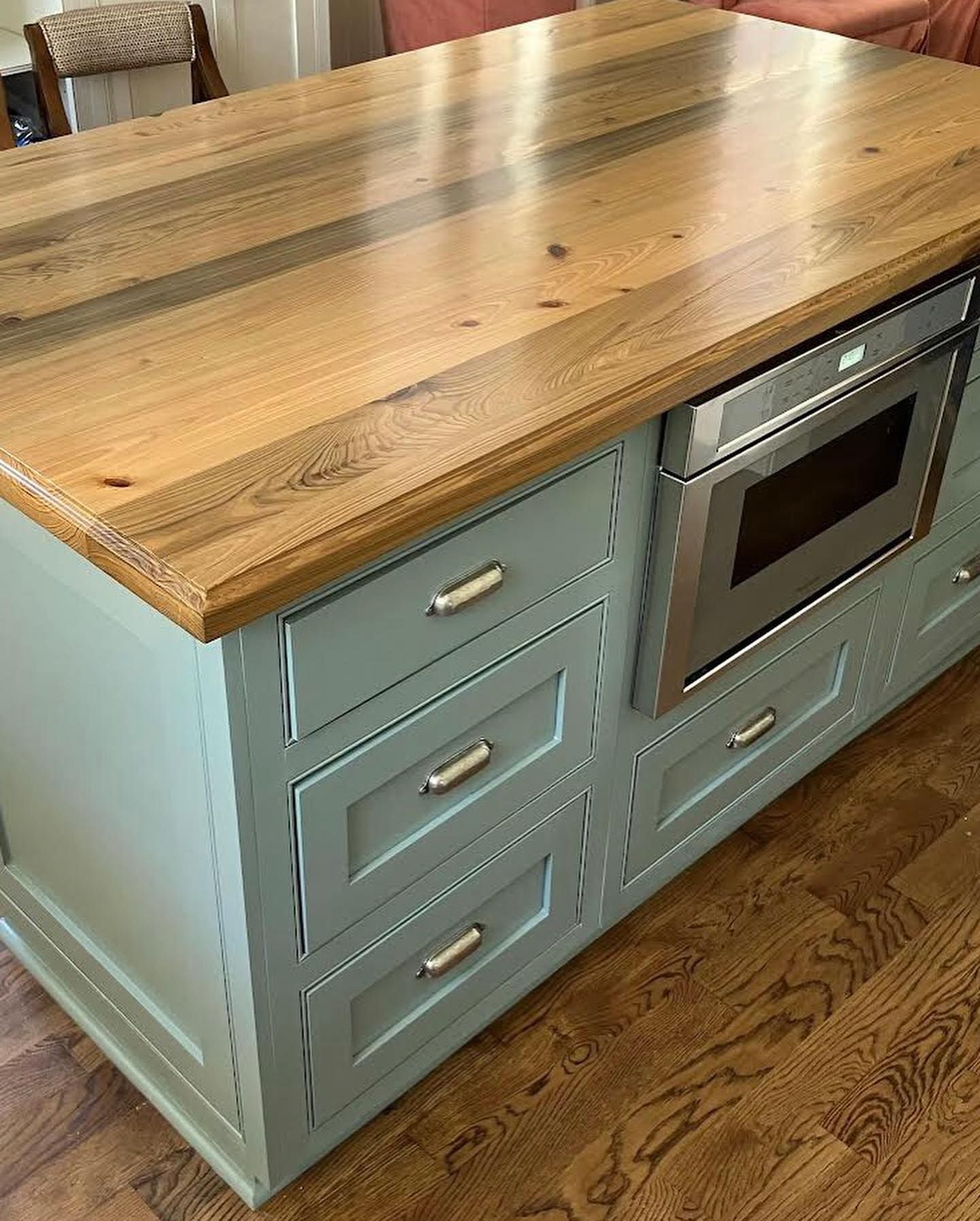 A wooden bat shaped tray with an orange ribbon on a wooden table.