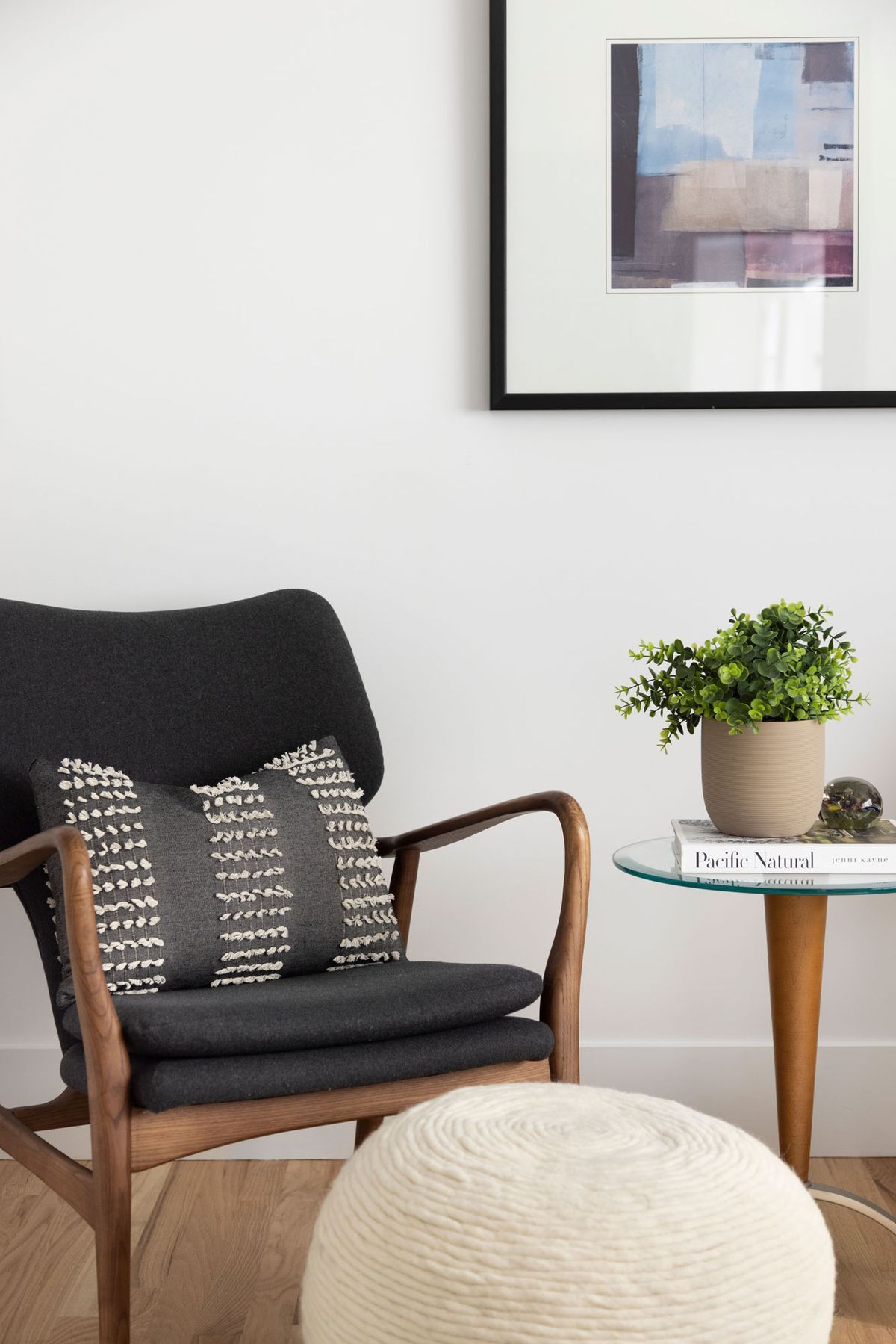 A chair with a pillow on it is sitting next to a table.