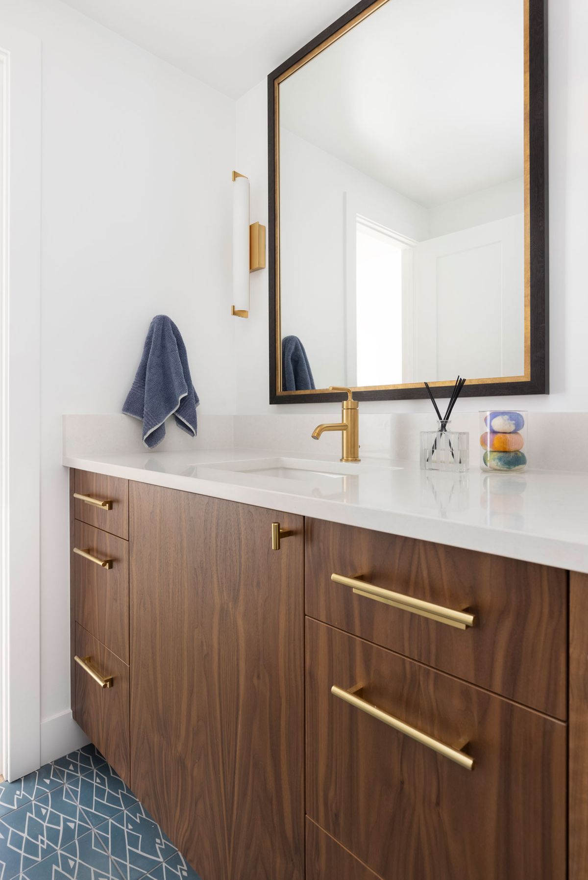 A bathroom with a sink, mirror, and wooden cabinets.