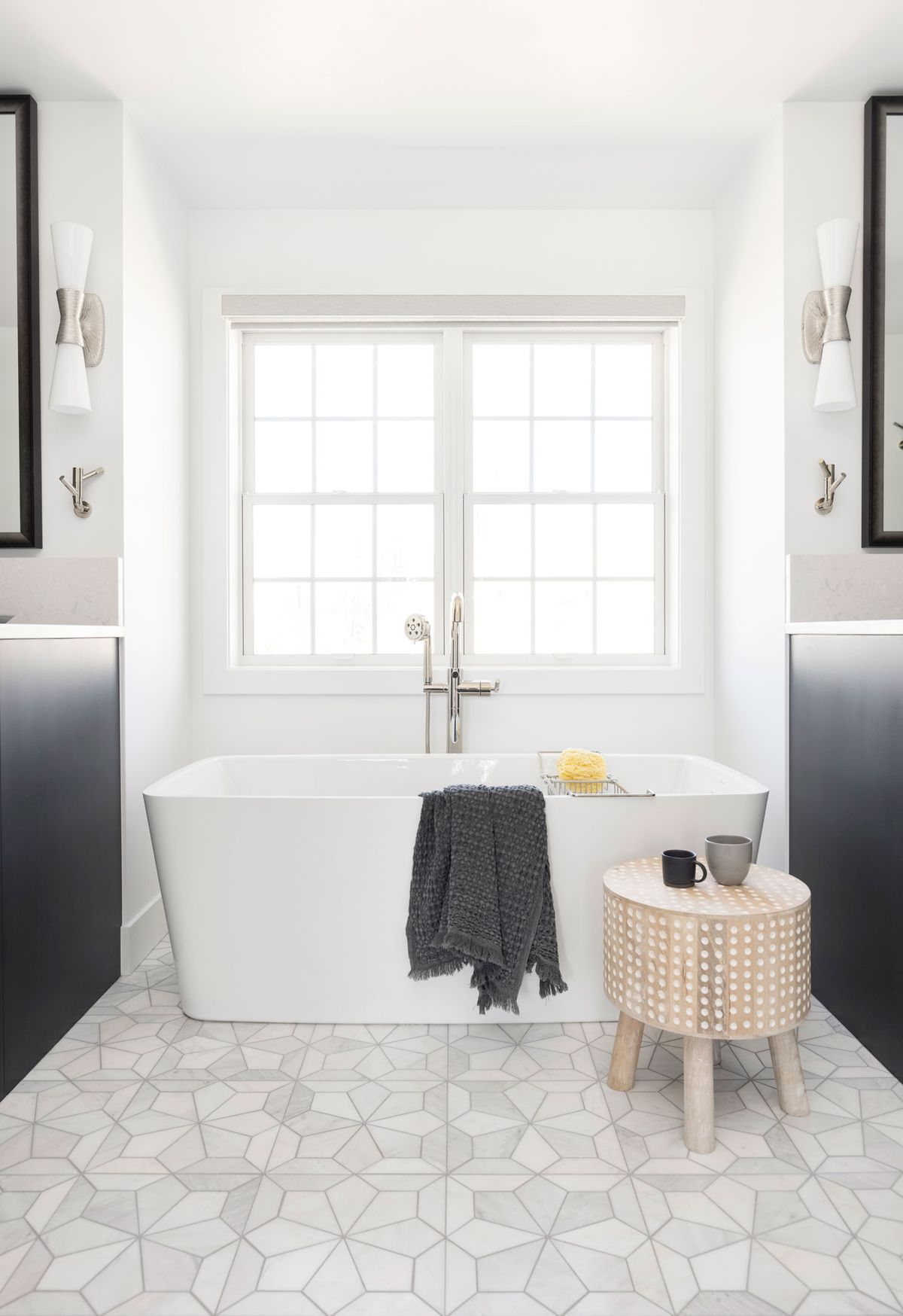 A bathroom with two sinks, a tub, and a window.