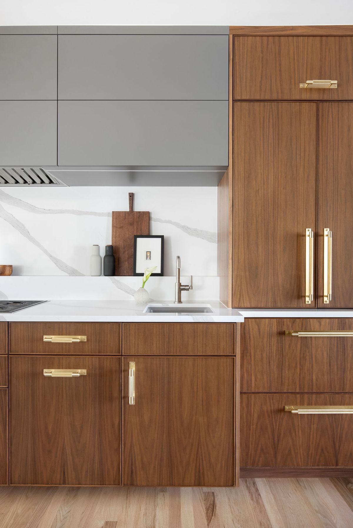 A kitchen with wooden cabinets, a sink, and a refrigerator.