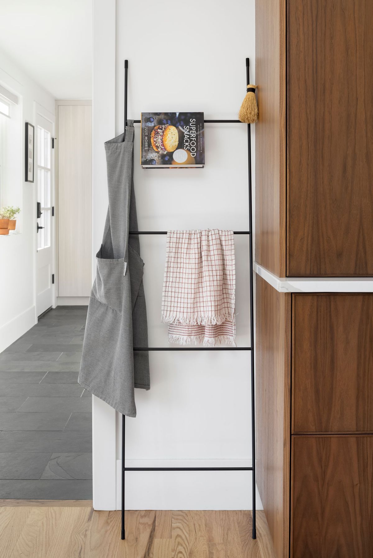 A ladder with towels hanging from it in a kitchen.