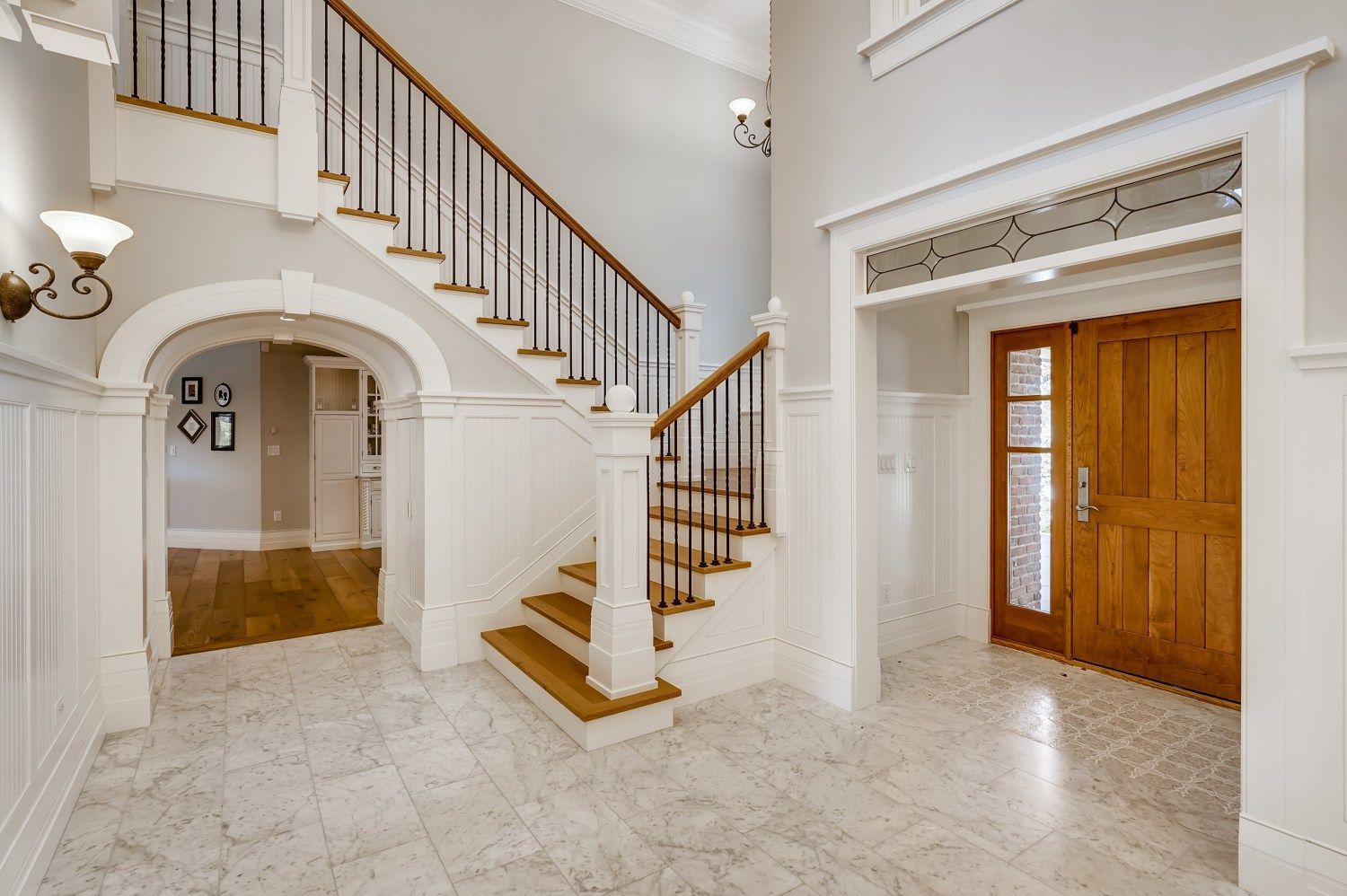 A hallway with a staircase and a door in a house.