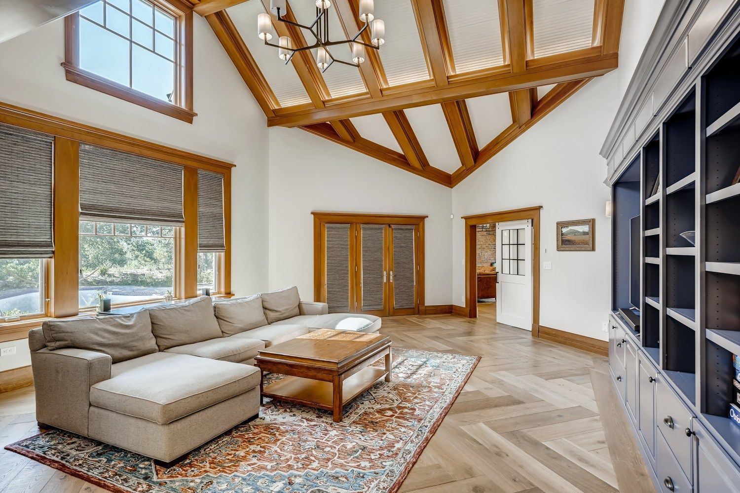 A living room with a couch, coffee table, and shelves.