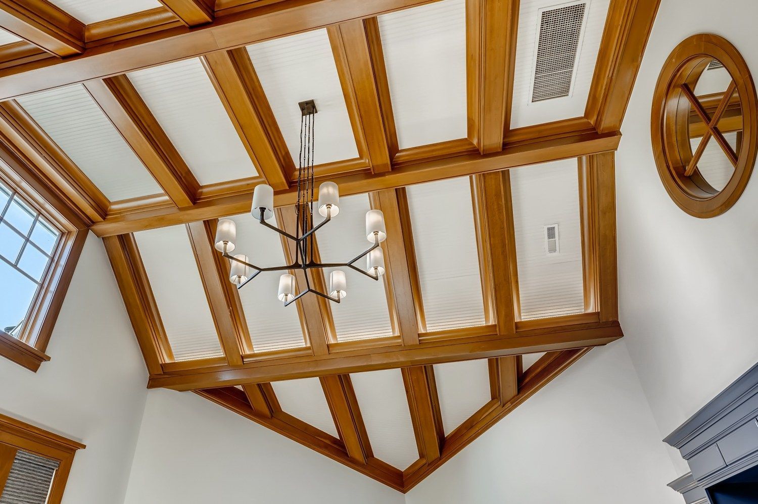 A wooden ceiling with a chandelier hanging from it.
