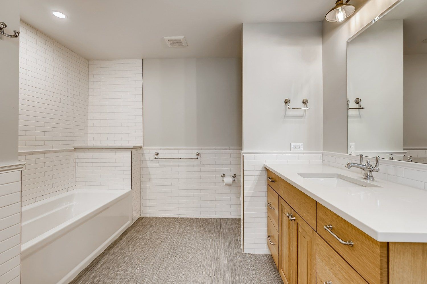 A bathroom with two sinks, a mirror, and a window.