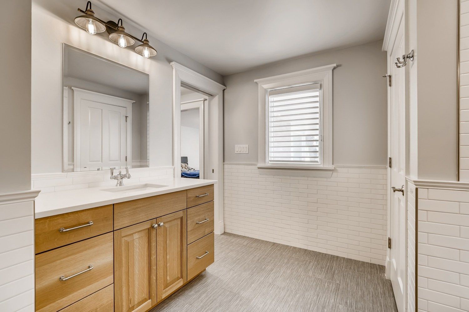 A bathroom with two sinks, a mirror, and a window.