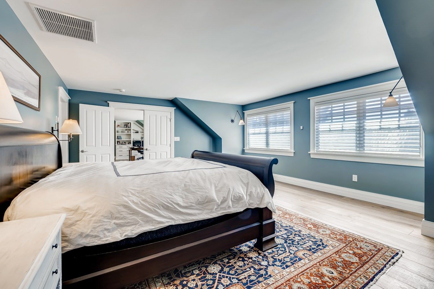 A bedroom with a king size bed and a rug.