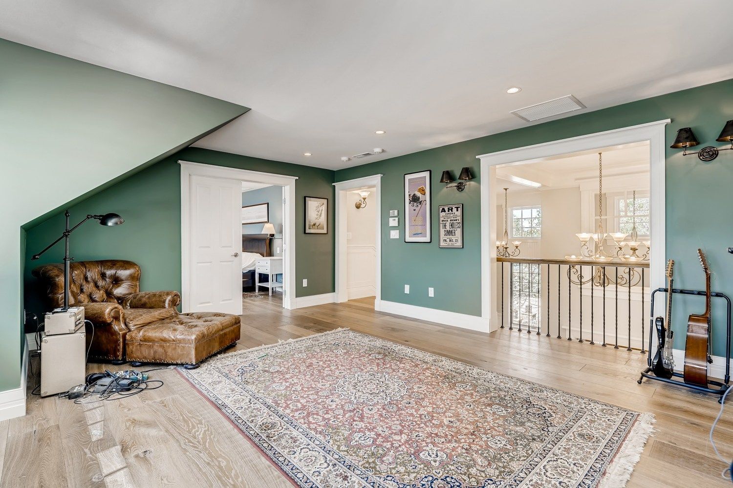 A living room with green walls and a rug.