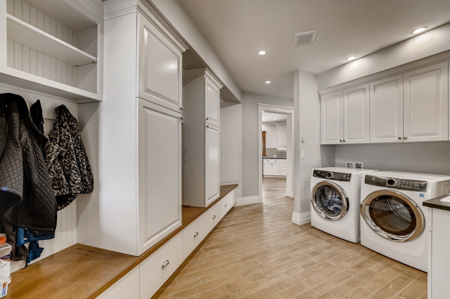A laundry room with a washer and dryer and a coat rack.
