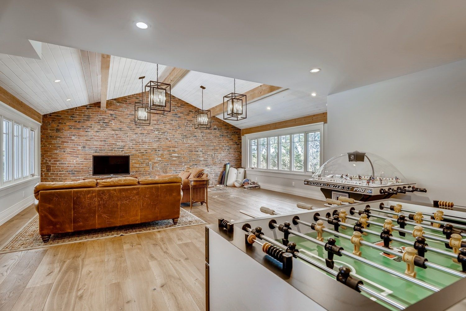 A living room with a foosball table and a couch.