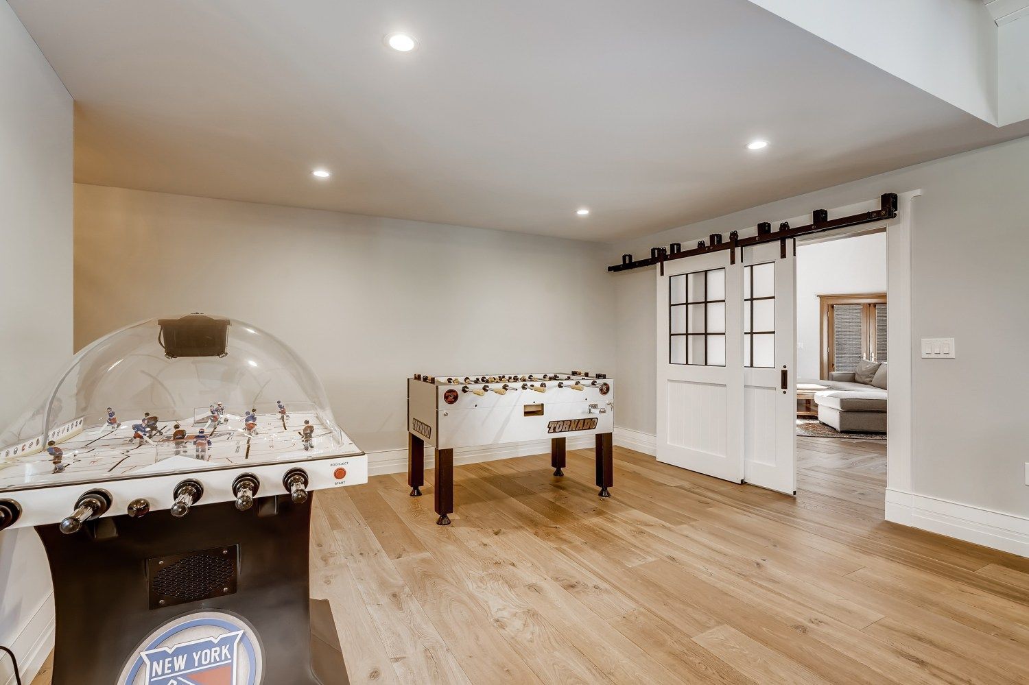 A game room with a foosball table and a sliding barn door.