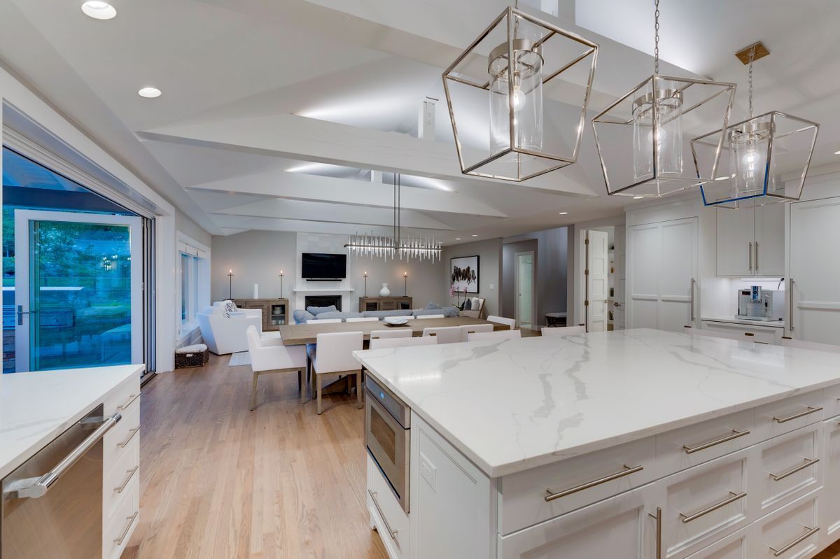 A kitchen with white cabinets and a large island in the middle