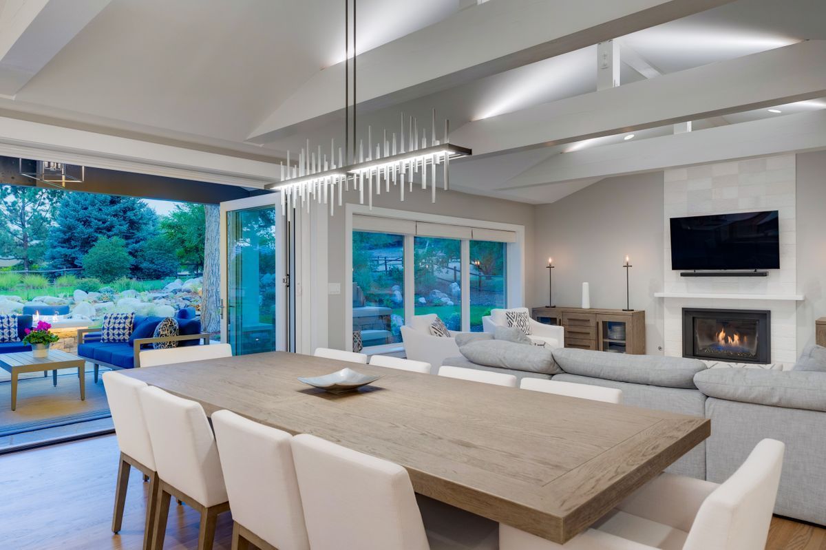 A dining room table and chairs in a living room with a fireplace.
