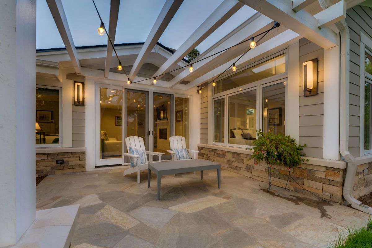 A patio with chairs and a table under a pergola