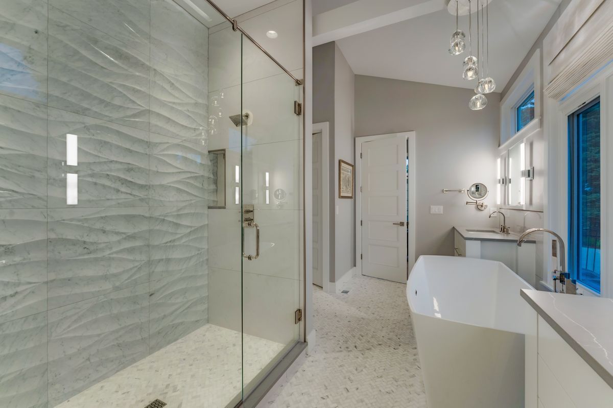 A bathroom with a walk in shower and a bathtub.