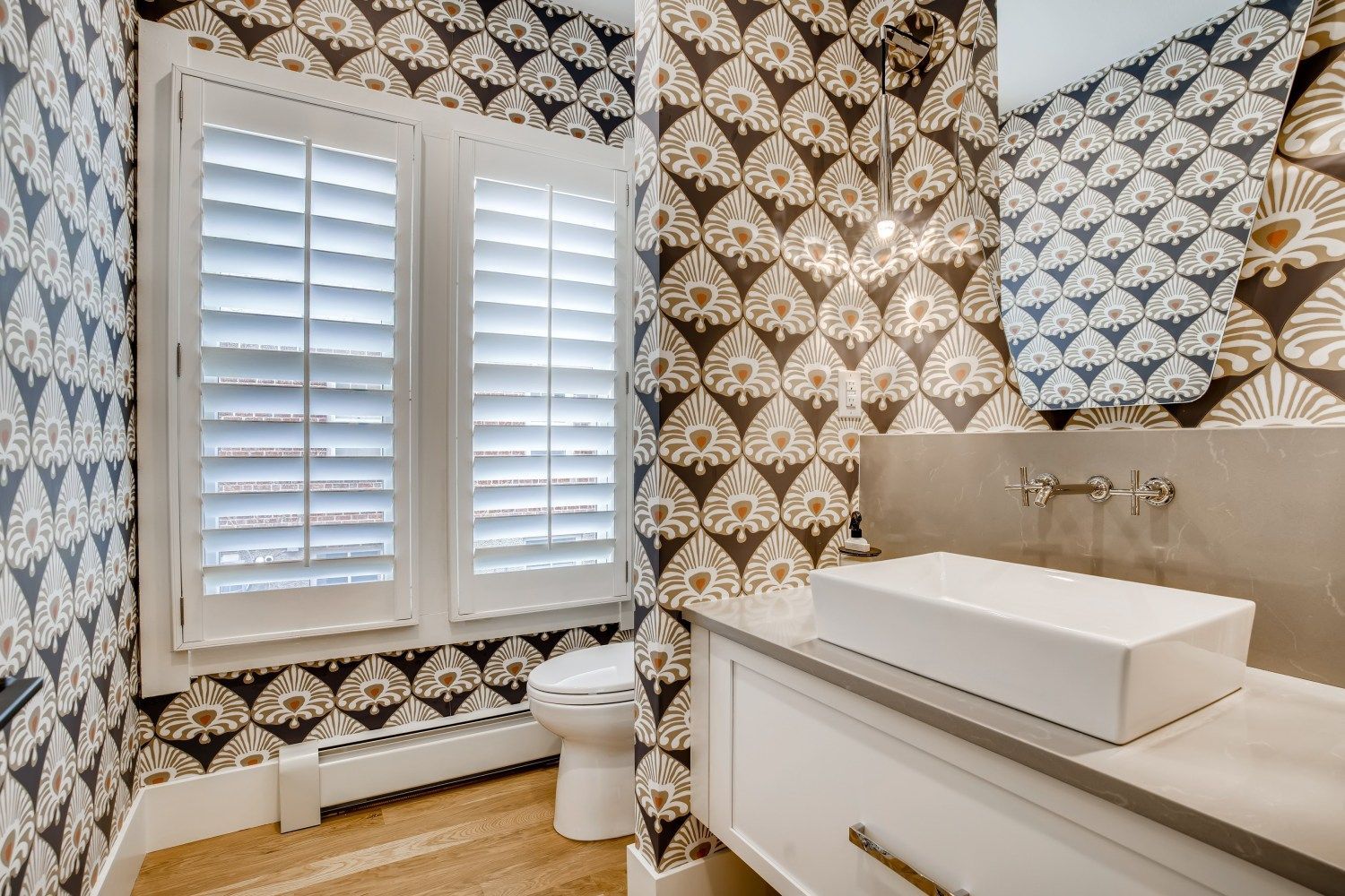 A bathroom with a sink, toilet, and mirror.