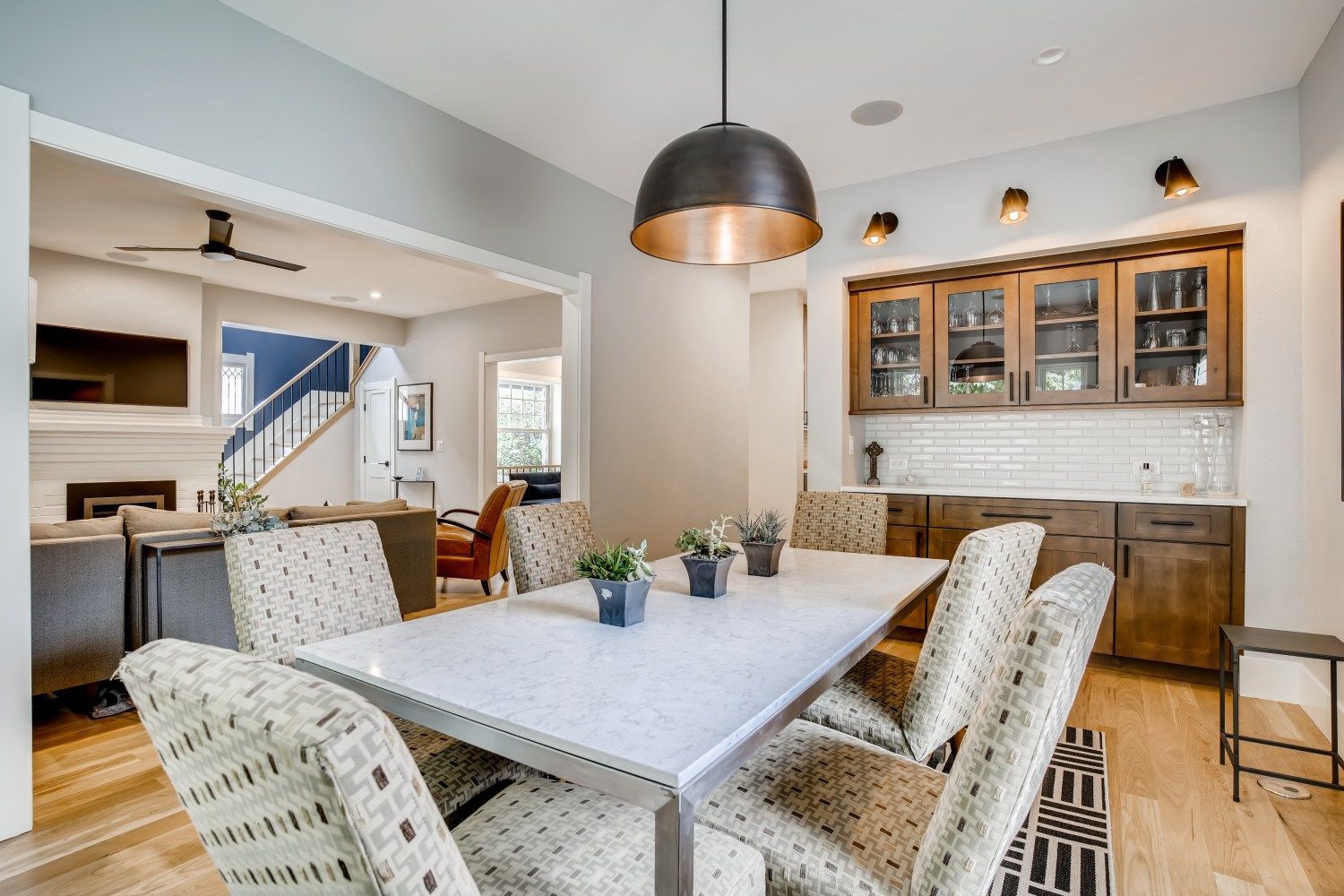 A dining room with a table and chairs and a ceiling fan.