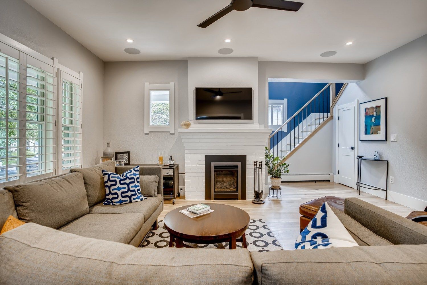 A living room with a fireplace, couch, table, and television.
